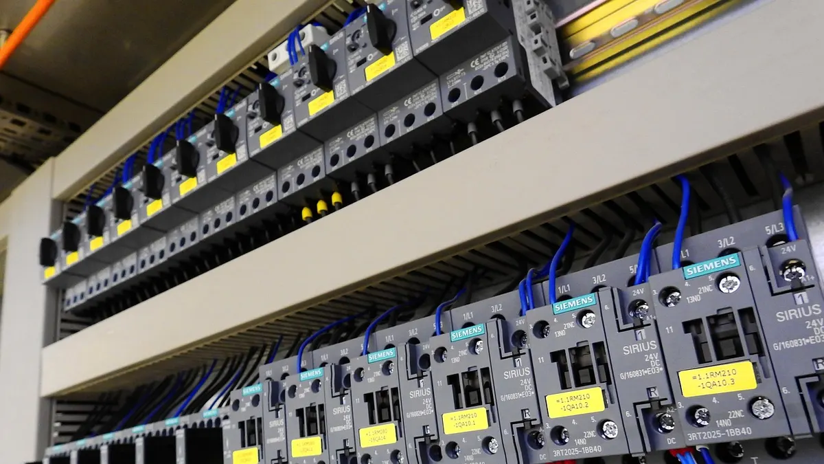 Quadro elétrico com fileiras de disjuntores e fios organizados