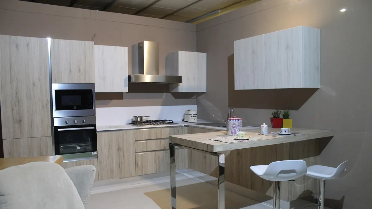 Cozinha moderna clara com armários, coifa e forno embutido